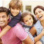 Portrait Of Happy Family In Garden At Home
